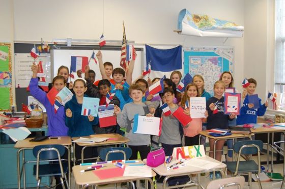 Children holding French flags in a FRENBRIDGE kids class