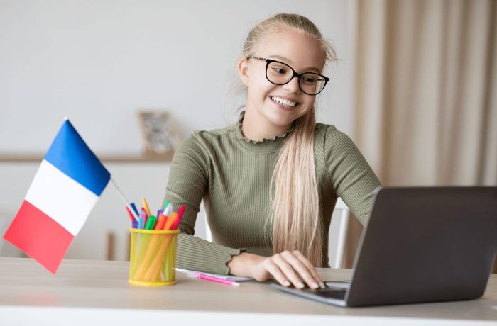 Student attending a live online French class on a laptop
